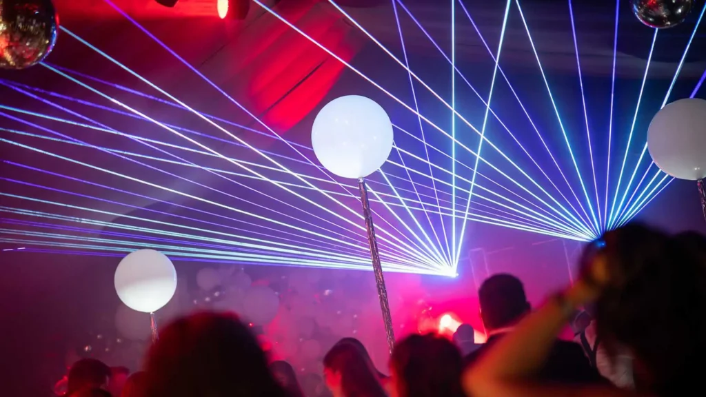 A party venue with laser lights, coloured orbs and guests dancing at a 40th Birthday Party