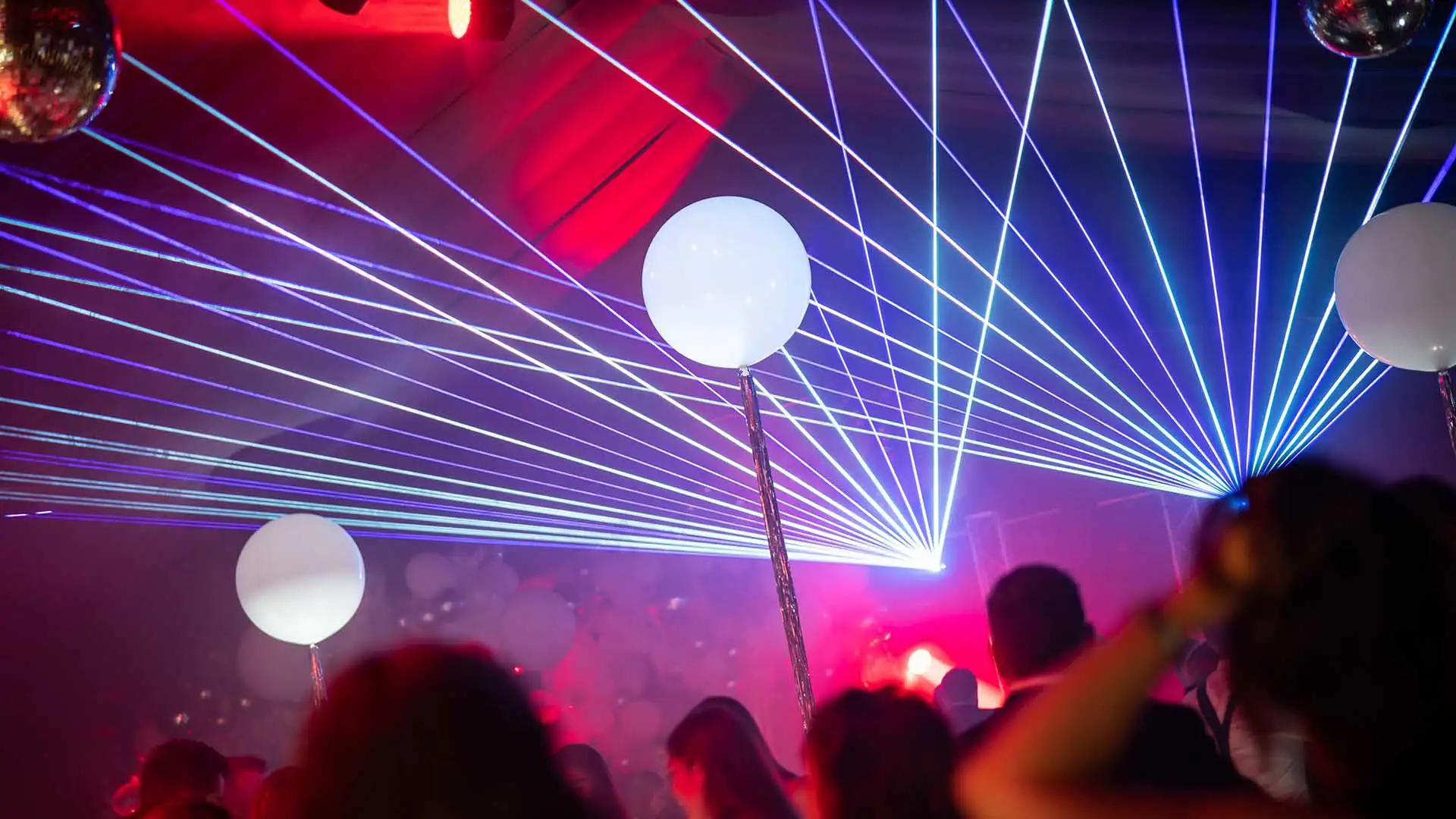 A party venue with laser lights, coloured orbs and guests dancing at a 40th Birthday Party