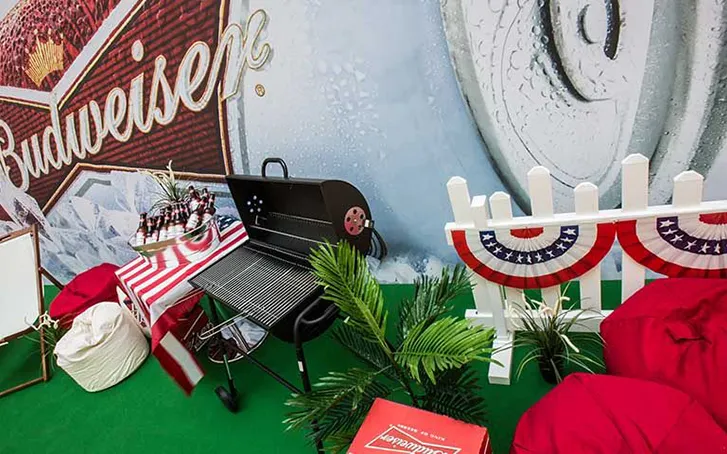 An area decorated in red, white and blue with a large Budweiser sign on the wall behind it