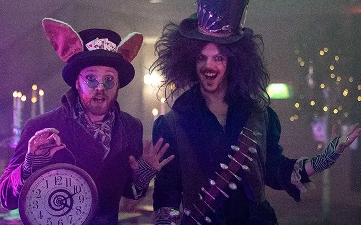 Two partygoers in Alice in wonderland fancy dress at an immersive experience party