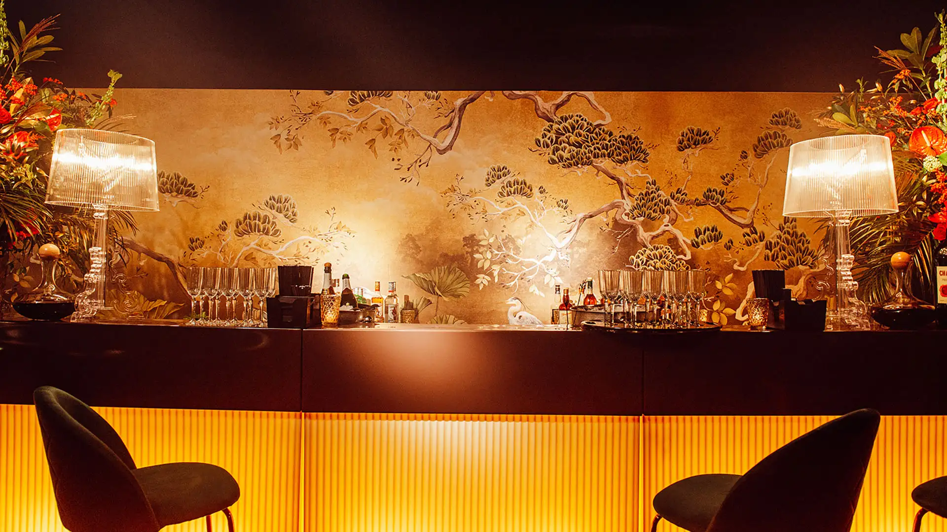 A bar in a private members club with two bars stools and mood lighting