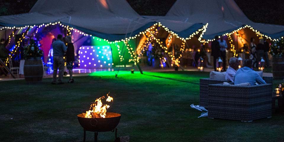 Tipi marquee for 60th wedding anniversary party fire pit and festoon lighting