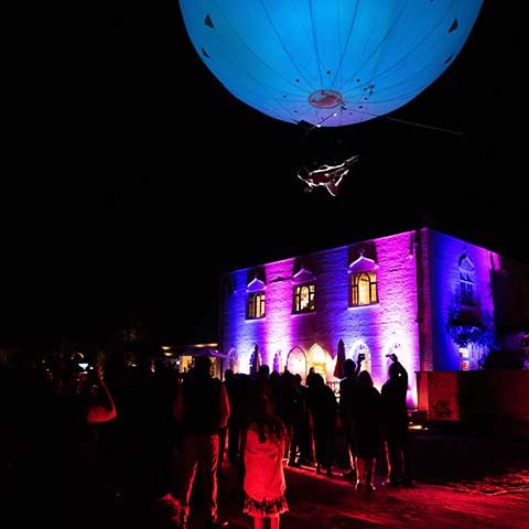 Heliosphere performing above guests at a house warming party