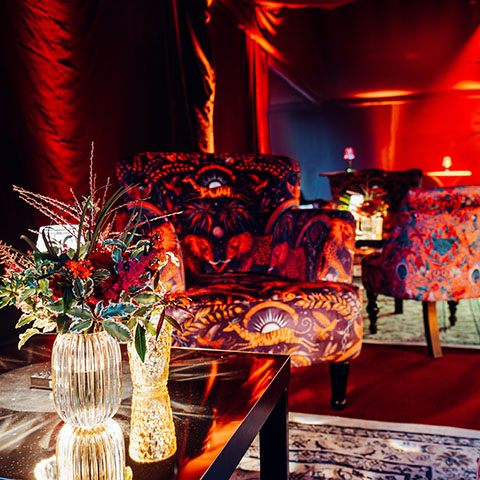 Lit coffee table with florals and colourful armchair