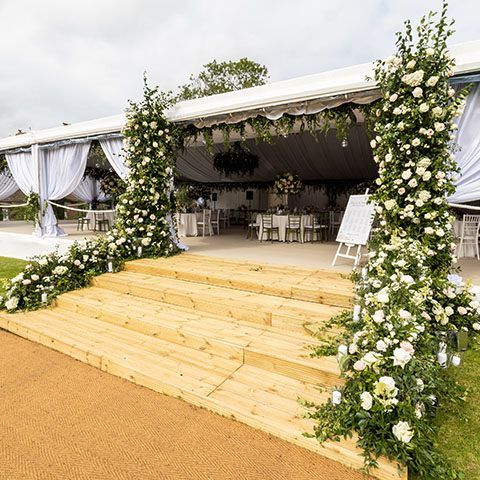 Wedding marquee entrance wooden steps with large floral display