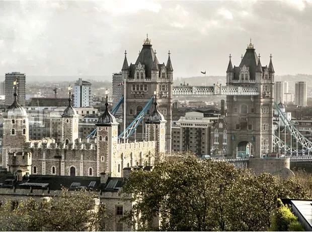 A landscape shot of Tower Bridge. It has faded colour with some trees popping up at the front.